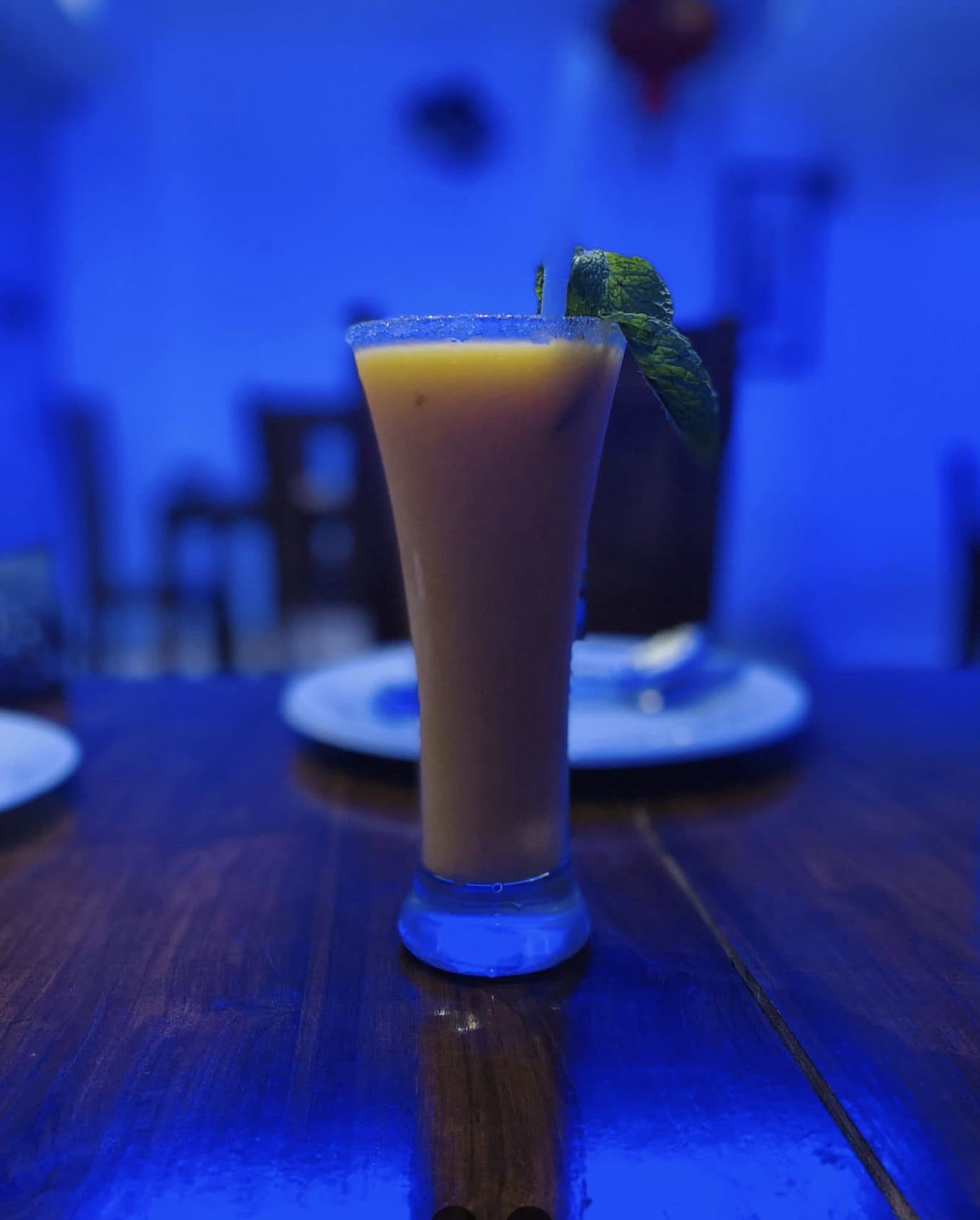 An iced tea beverage garnished with mint, served at a table inside Ranmo
