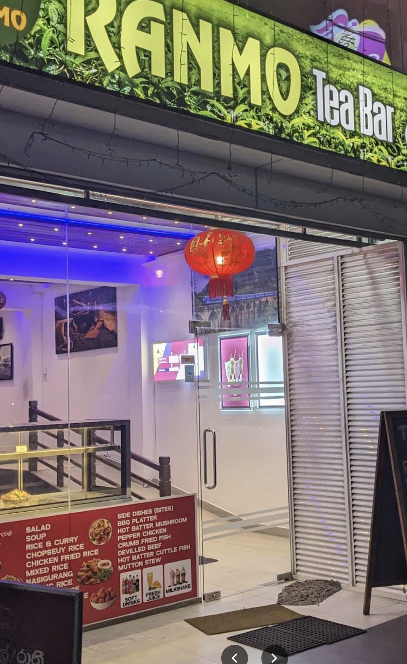 Ranmo Tea Bar and Restaurant's illuminated storefront at night, with red lanterns at the entrance