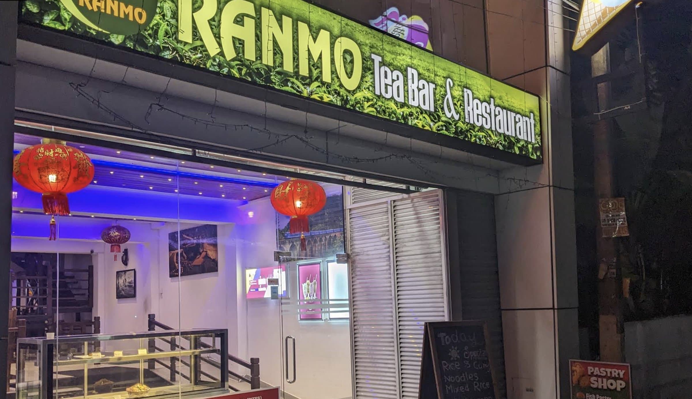 Ranmo Tea Bar and Restaurant's illuminated storefront at night, with red lanterns at the entrance